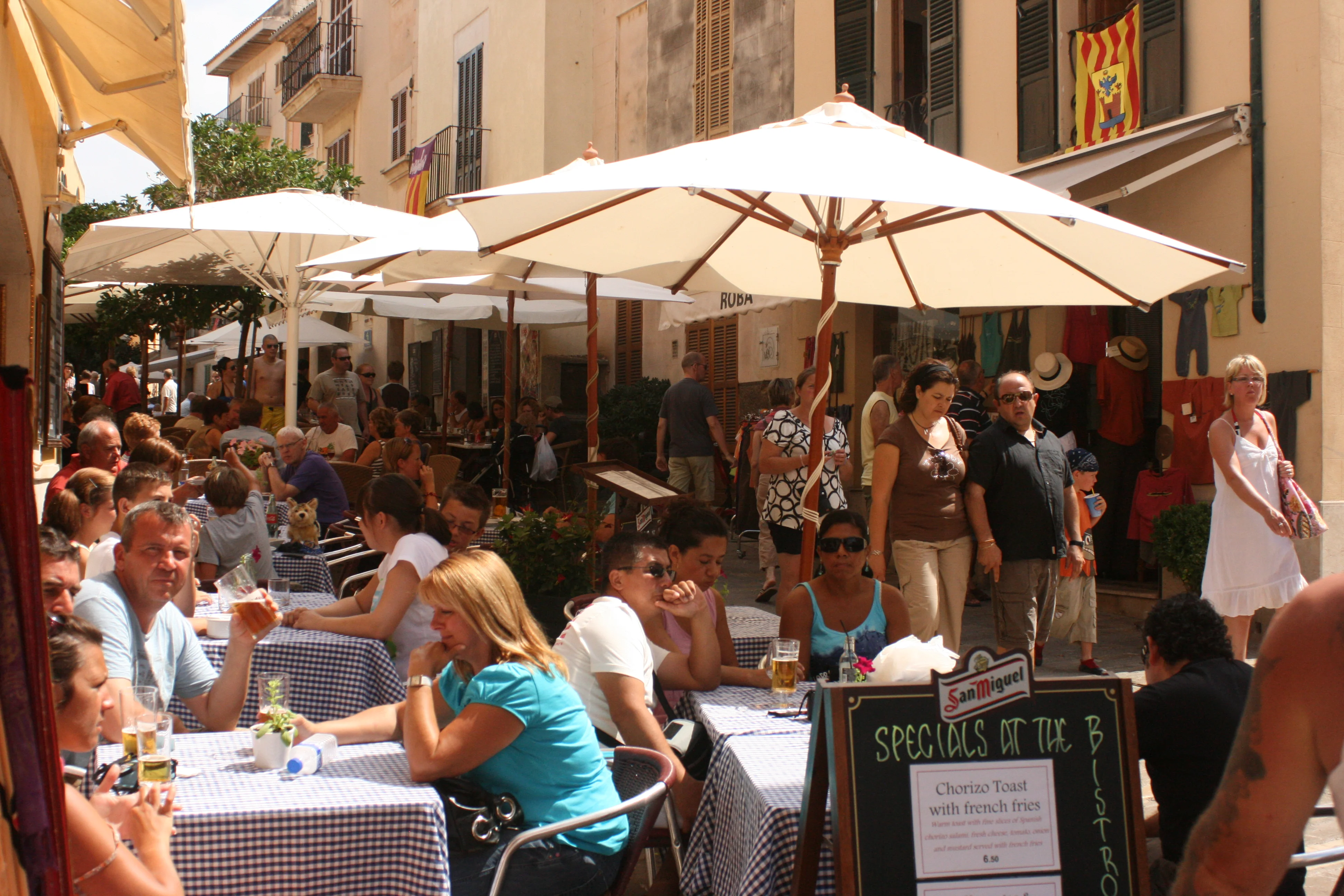 Tables set on a terrace outside a traditional restaurant in Alcudia old town at dusk