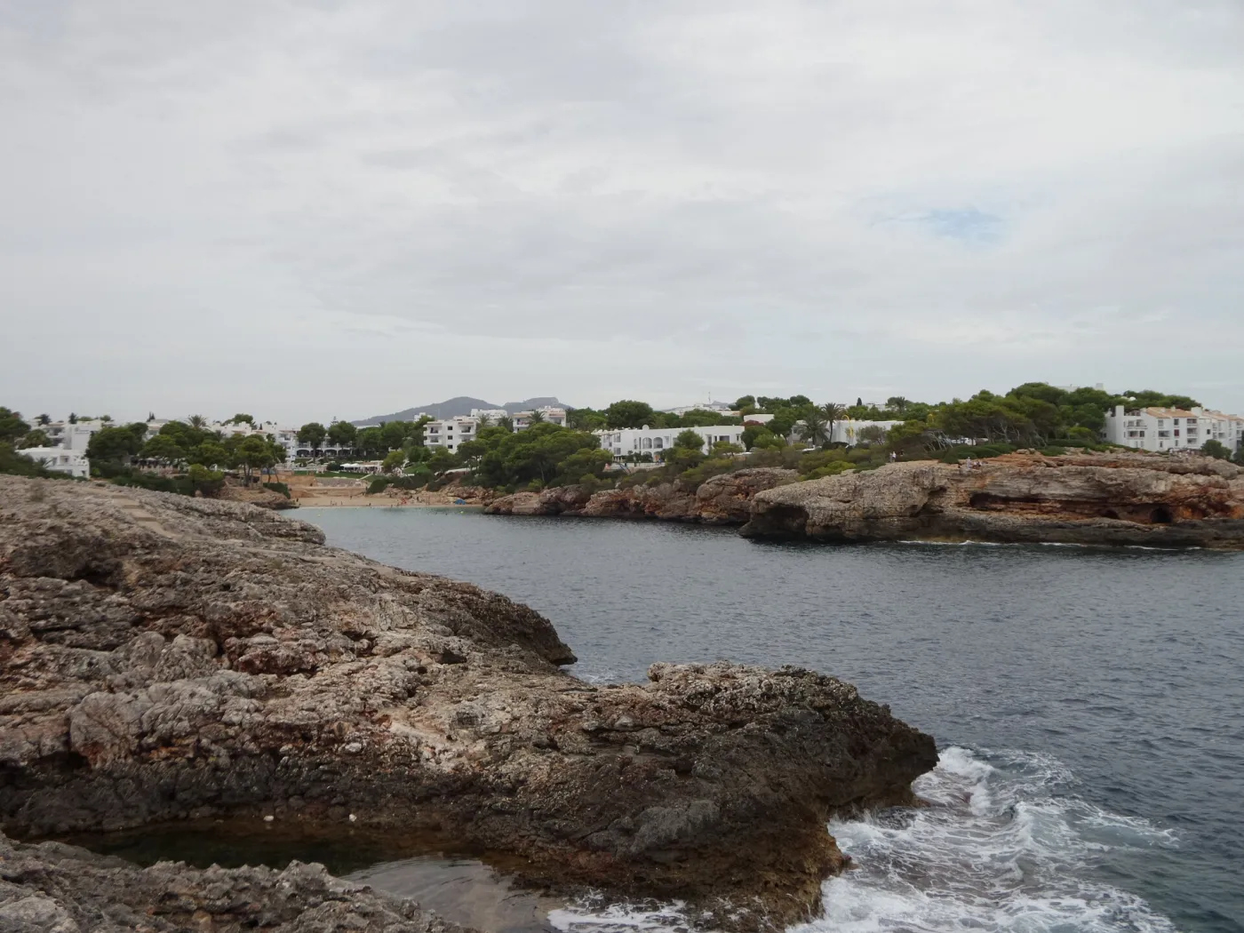 Crystal clear emerald water at Cala Esmeralda beach surrounded by cliffs