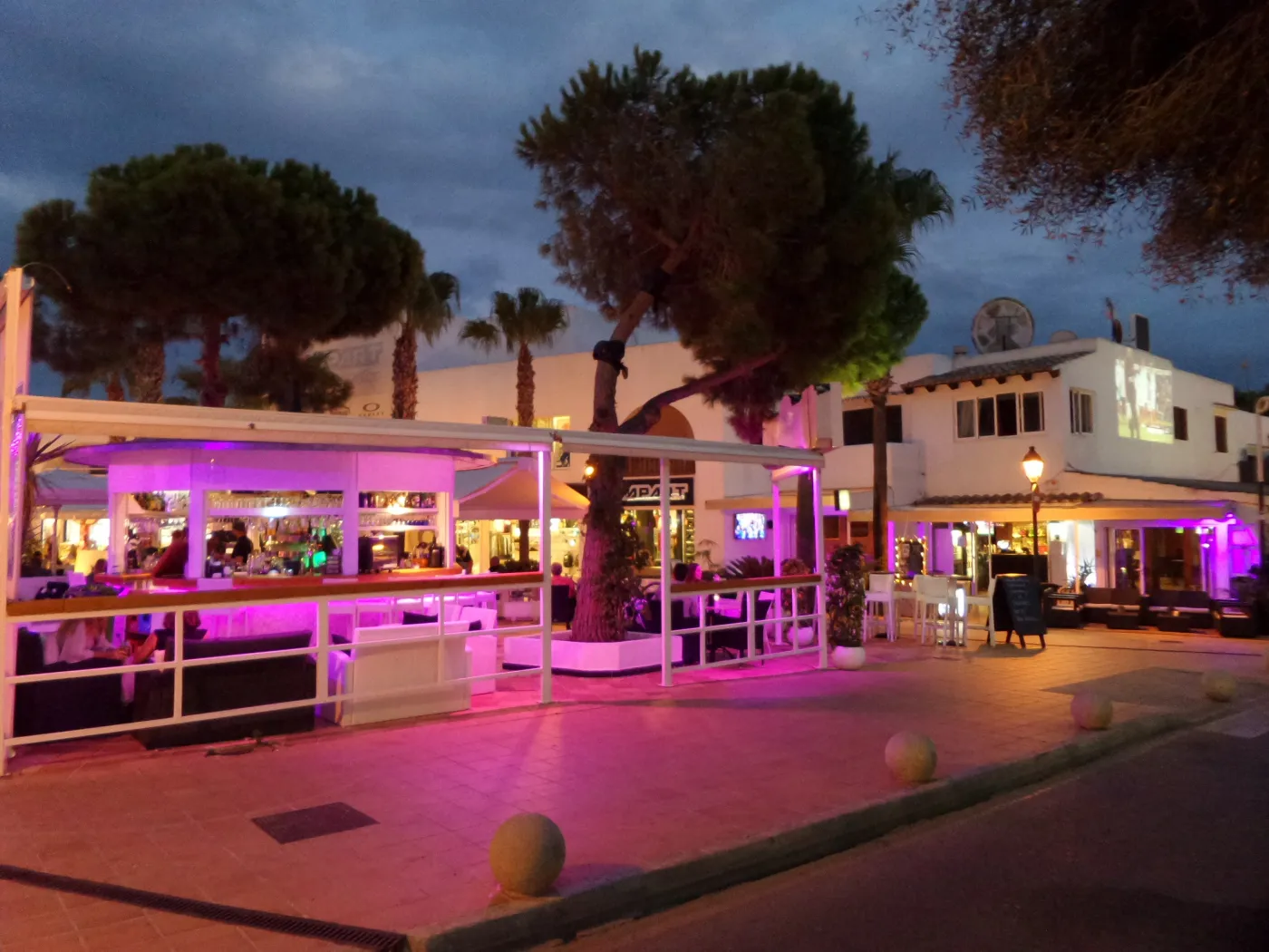 Lit-up cocktail bar in Cala d'Or at dusk with purple neon lights