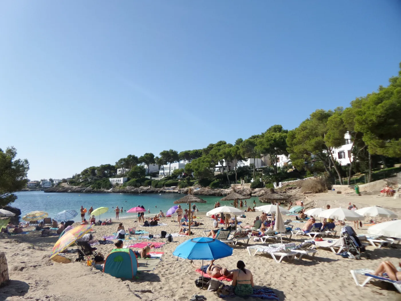 Whitewashed buildings and turquoise cove at Cala d'Or, Mallorca