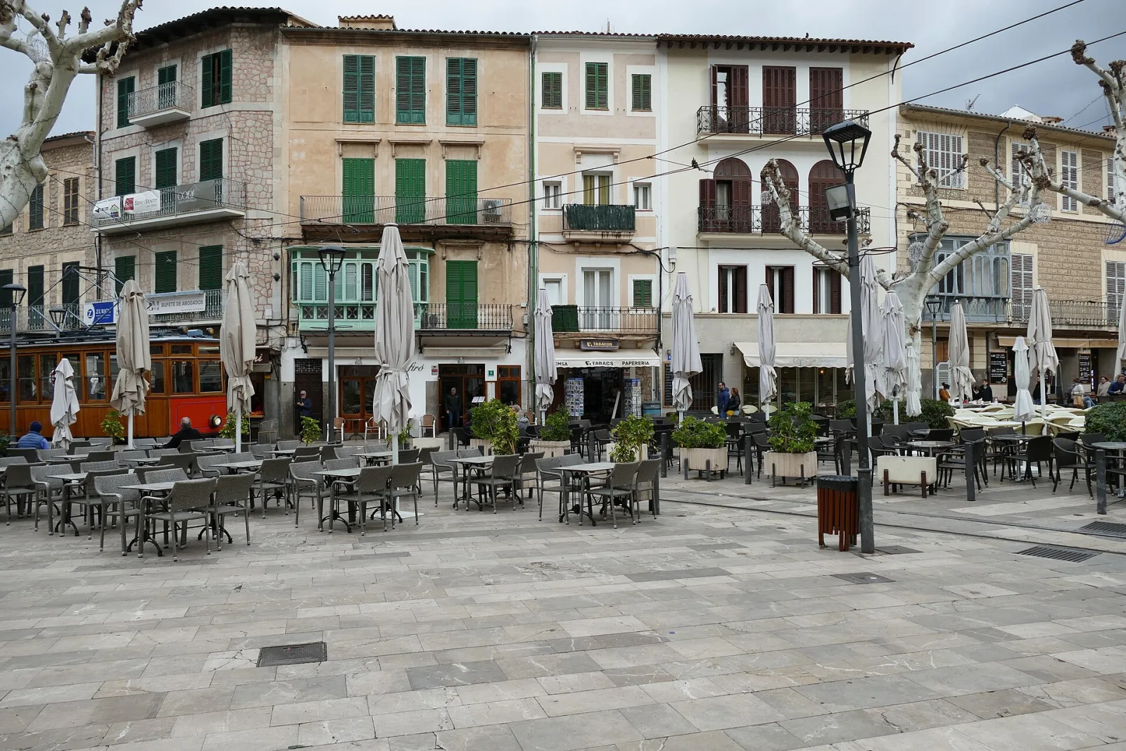 The historic open-sided wooden tram passing through Plaça de la Constitució in Sóller